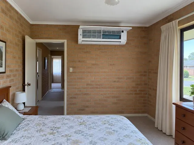 Clean split system on an internal brick bedroom wall with open front panel and visible filters in Elizabeth Grove